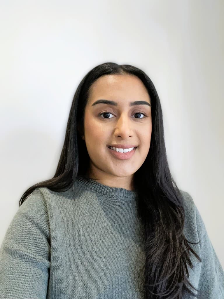 Imanjit Kaur smiling, wearing a grey jumper